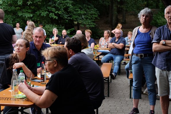 Gäste hören beim Sommerfest den Reden zu