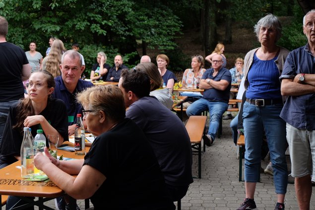 Gäste hören beim Sommerfest den Reden zu