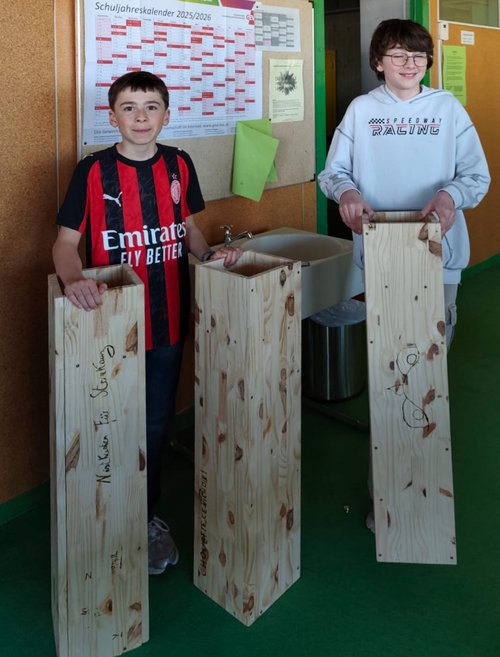 Zwei Schüler aus Manosque mit Nistkästen für Steinkäuze