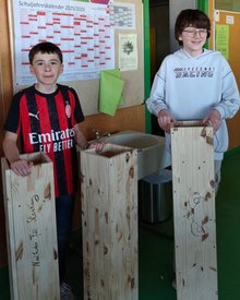 Zwei Schüler aus Manosque mit Nistkästen für Steinkäuze
